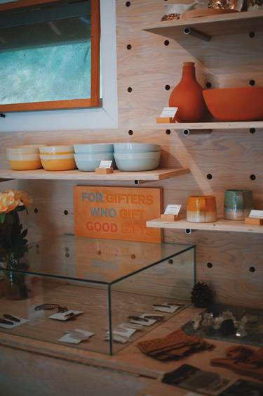 Pottery and gifts on wooden shelves on a wooden wall