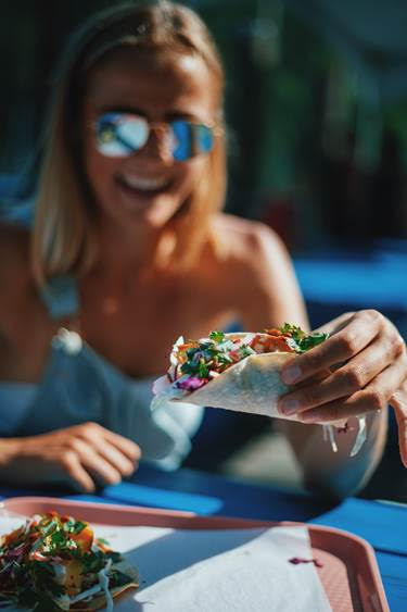 Woman smiling while holding a taco