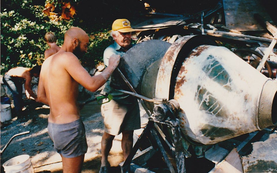 Two men operating a cement mixer