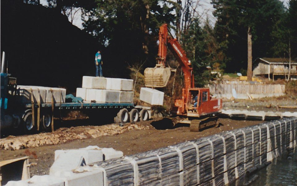 Excavator putting blocks in a concrete wall