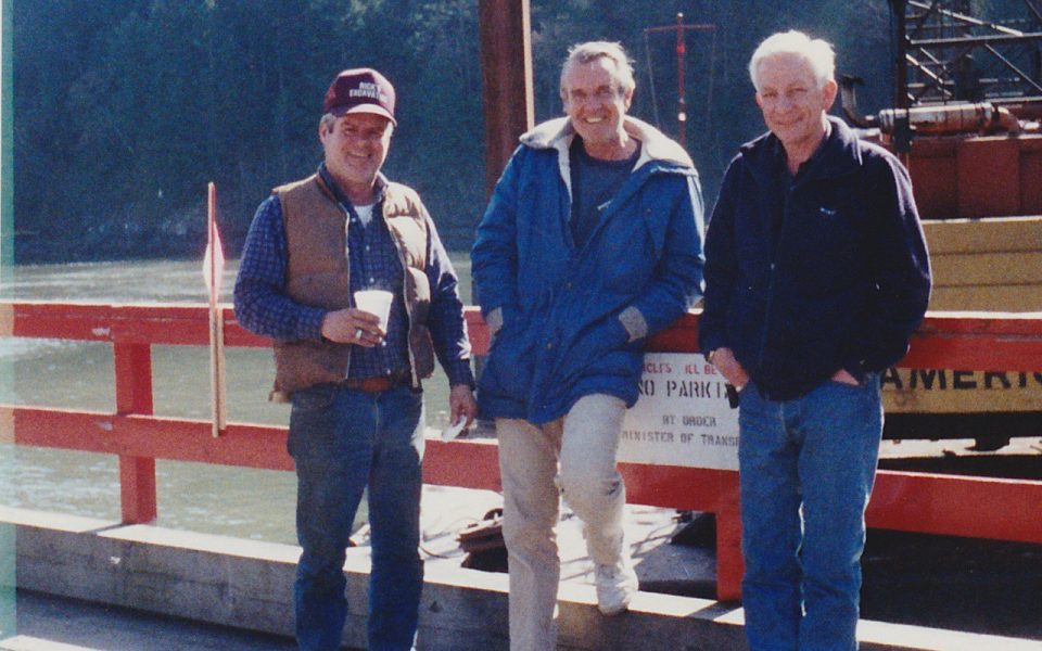 Three men standing in front of a railing