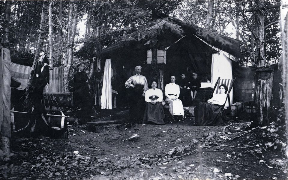 Black and whit photo of people at a camp site